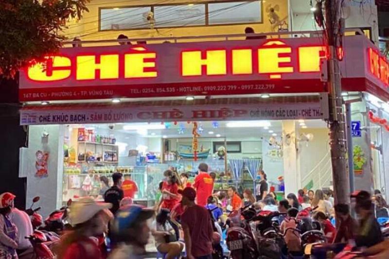 Một gian hàng bán chè Huế với nhiều loại chè đa dạng màu sắc, được bày trong cốc hoặc bát nhỏ, sẵn sàng phục vụ thực khách